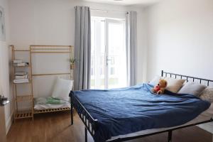 a teddy bear sitting on a bed in a bedroom at Top-Floor Penthouse with Panoramic Views in Romford