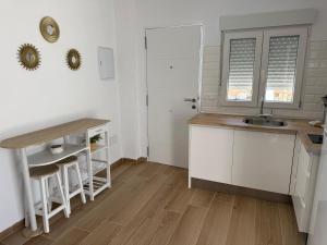 a kitchen with white cabinets and a sink and a counter at Casitas mis niñas in Barbate +2 photos