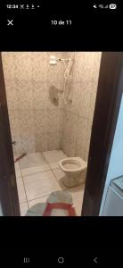 a bathroom with a toilet in a tiled room at Repouso Alegre in Araguari