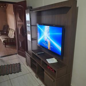 a flat screen tv in a wooden entertainment center at Repouso Alegre in Araguari