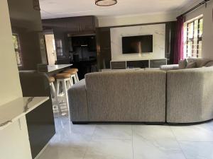a living room with a couch and a kitchen at Thabi's Place in Matatiele