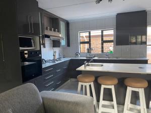 a kitchen with a counter and stools in it at Thabi's Place in Matatiele