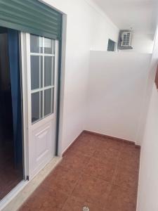 a room with a door and a tile floor at Hospedaria Singularys in Campo Maior