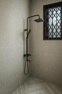 a shower with a shower head in a bathroom at Brand New Royals Retreat 2BR 3BA in Oyarifa