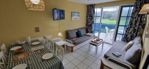 a living room with a couch and a table at Appartement 4-7 pers Grande terrasse vue golf Accès piscine et océan in Talmont