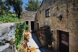 an old stone building with benches and a door at Casas Serranas in Gouveia