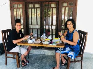 two women sitting at a table eating food at Kottamba Villa Tangalle in Tangalle +45 photos
