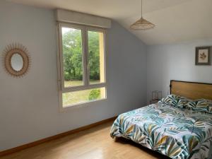 a bedroom with a bed and a window at Maison mitoyenne proches des plages in Bénesse-Maremne
