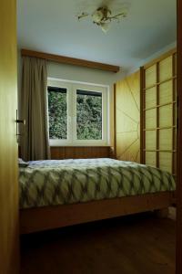 a bedroom with a bed and two windows at Charmantes Einfamilienhaus in Größing