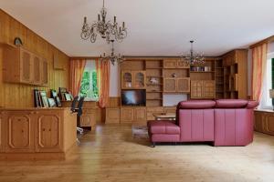 a living room with a pink couch and a tv at Charmantes Einfamilienhaus in Biedermannsdorf
