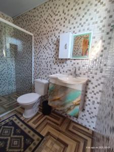 a bathroom with a sink and a toilet at Pousada Traineira in Trindade