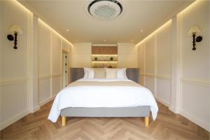 ein Schlafzimmer mit einem großen Bett mit weißer Bettwäsche in der Unterkunft Hestiana in Ban Hua Khao Sammuk