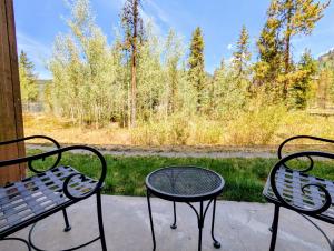 two chairs and a table on a porch with a view at Springs 8806 by SummitCove Lodging in Colorado in Keystone