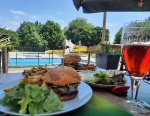 une table avec deux assiettes de nourriture et un verre de bière dans l'établissement Camping Le Moulin des Effres, à Secondigny