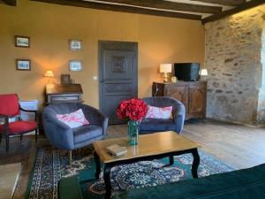 a living room with two chairs and a table at Maison du Chapitre in Prudhomat