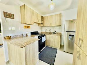 a kitchen with wooden cabinets and a counter top at Apartment 3 rooms terrace Wi-Fi Distrito Naciona in Pantoja +15 photos