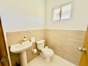 a bathroom with a toilet and a sink and a window at Apartment 3 rooms terrace Wi-Fi Distrito Naciona in Pantoja