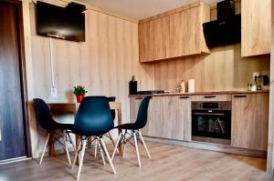 Przycup w Karkonoszach Apartamenty Słoneczna dolina 7B - domek na wyłączność w Karkonoszach في Mniszków: مطبخ بأربعة كراسي وطاولة وكاونتر