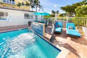 ein Swimmingpool mit zwei Stühlen und einem Sonnenschirm in der Unterkunft Sea Star Suites By The Sea in Fort Lauderdale