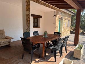 a wooden table and chairs on a patio at Chorros del Mundo turismo rural in Riópar +50 photos