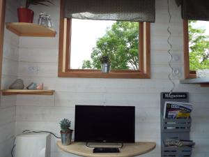 a computer monitor sitting on a desk under a window at Tiny House "Les Vallées" in Saint-Quentin-sur-le-Homme +52 photos
