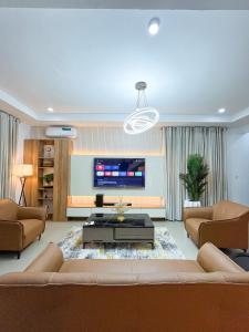 a living room with a couch and a tv at Kind Maisonettes Apartments in Abuja +22 photos