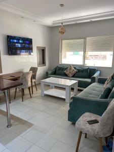 a living room with a green couch and a table at Cozy Relax in Mohammedia