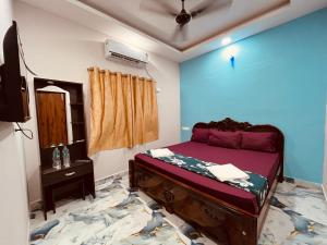 Una habitación con una cama y un televisor. en Nikilan Residency, en Rameswaram