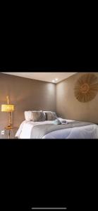 a bedroom with two beds and a lamp on the wall at Casa Zouk, charme e alto padrão in Japaratinga