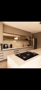 a kitchen with a stove top oven in it at Casa Zouk, charme e alto padrão in Japaratinga +8 photos