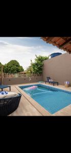 a swimming pool with two lounges and a table at Casa Zouk, charme e alto padrão in Japaratinga