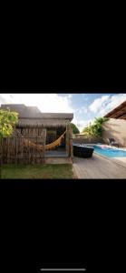 a view of a pool with a gazebo and a swimming pool at Casa Zouk, charme e alto padrão in Japaratinga