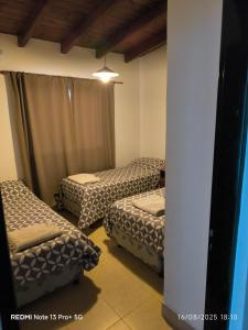 a room with two twin beds and a column at Cafayate Deptos in Cafayate