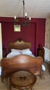 a bed with a wooden headboard and a table in a room at Petite maison de brocanteur à Charbonnières in Charbonnières-les-Bains