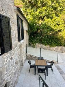 una mesa y sillas sentadas junto a un edificio de piedra en Casa rural Reibón, en Moaña