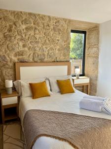 Casa rural Reibón في موانيا: غرفة نوم بسرير كبير وبجدار حجري