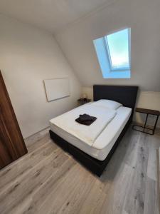 a bedroom with a large white bed with a window at SR Ferienwohnung Wagenfeld in Wagenfeld