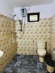 a bathroom with a shower and a toilet and a sink at Sigiri Niwahana Home Stay in Sigiriya