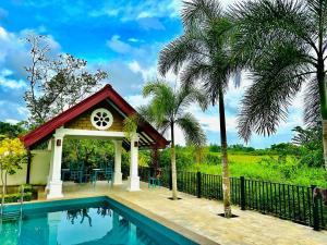 a villa with a swimming pool and a house at SAMA KAMI Ayurvedic Resort & Villa in Polatupalata