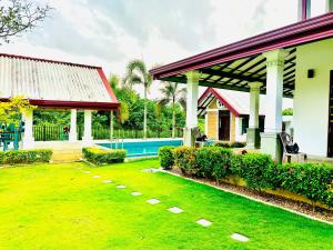 a house with a yard with a swimming pool at SAMA KAMI Ayurvedic Resort & Villa in Polatupalata
