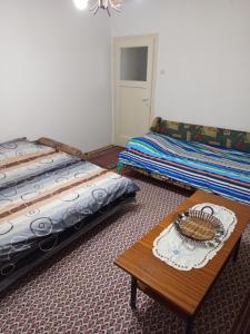 a bedroom with two beds and a table with a basket on it at Apartman Markovic in Vranje