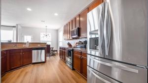 a kitchen with wooden cabinets and a stainless steel refrigerator at May 25' Reno ~Poker-Pool-Ping Pong-Shuffleboard in San Antonio