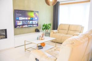 a living room with two couches and a tv at Villa-gey Escape in Bekkevoort