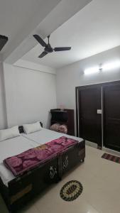 a bedroom with a bed and a ceiling fan at Budhibhaihomstay in Bīr
