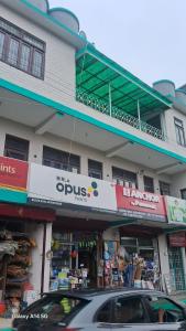 a building with a car parked in front of it at Budhibhaihomstay in Bīr