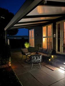a patio with a couch and a table at night at Huis Frieda am See, Nähe Arnheim in Lathum