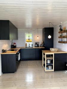 a kitchen with black cabinets and a wooden counter top at Great cabin in beautiful nature in Ørsta