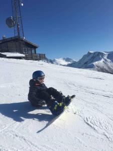 a person is sitting in the snow on a snowboard at Great cabin in beautiful nature in Ørsta +24 photos