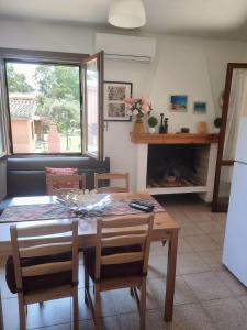 a dining room with a table and a couch at Case Natalia in Costa Rei