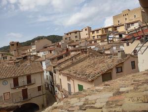 a group of buildings on a hill with roofs at Cal Fuster I in Todolella